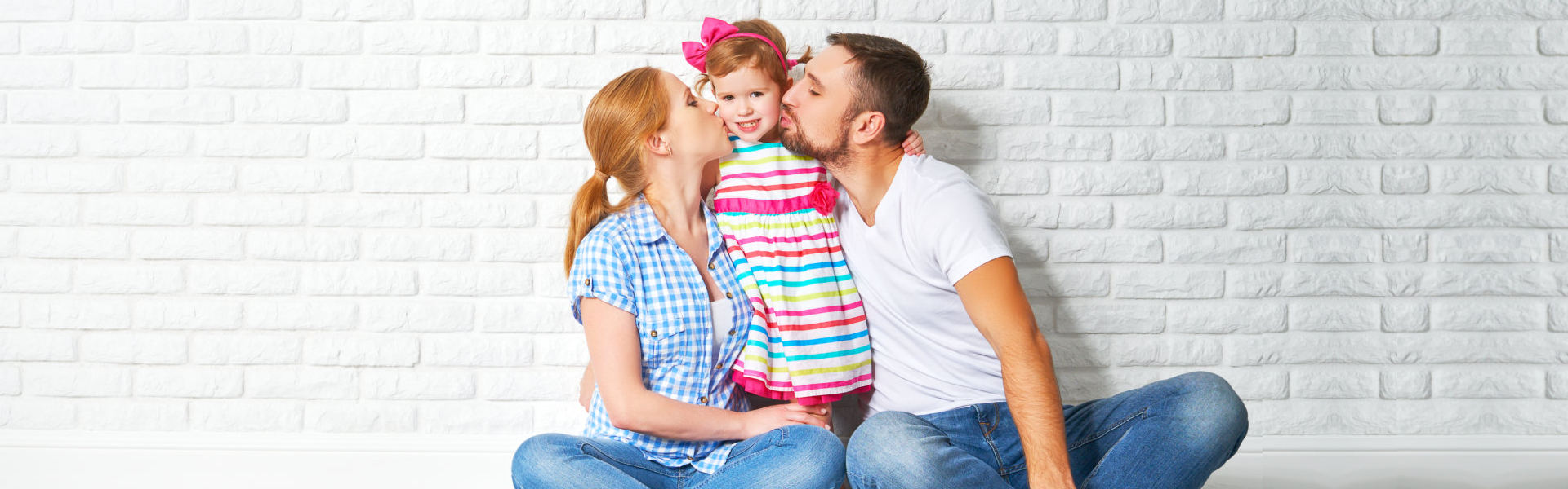 parents kissing their daughter