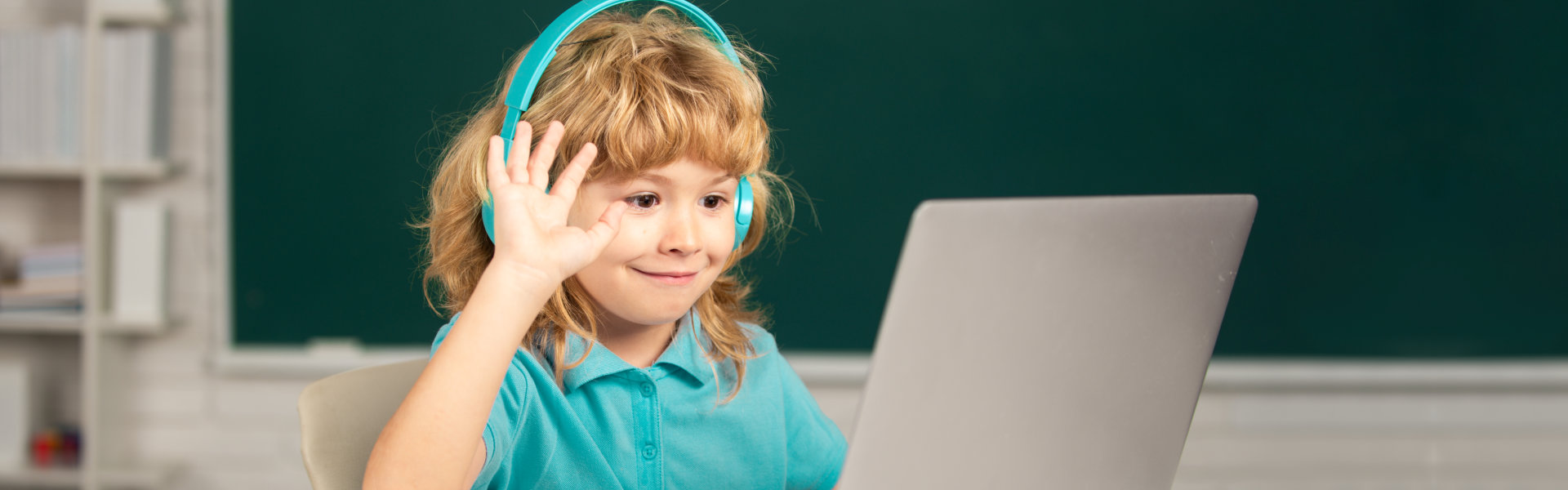 child waving in front of the computer